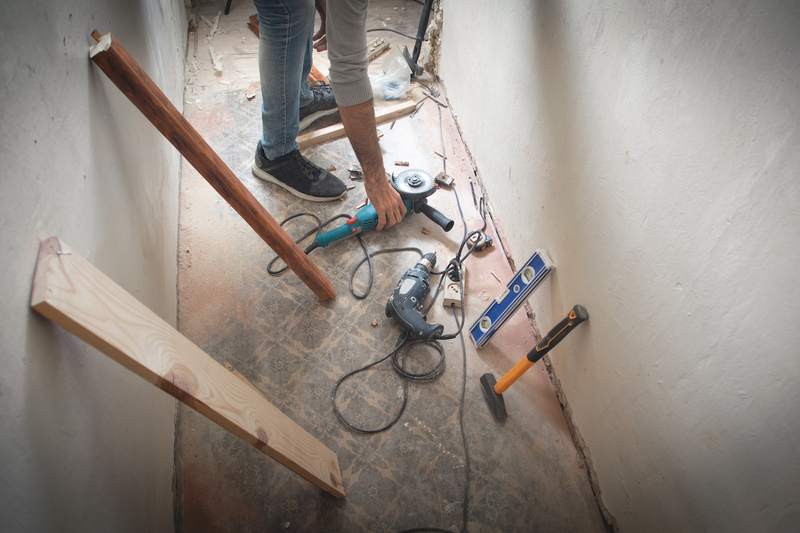 A man reaches for a circular saw while working on a fixer-upper home.